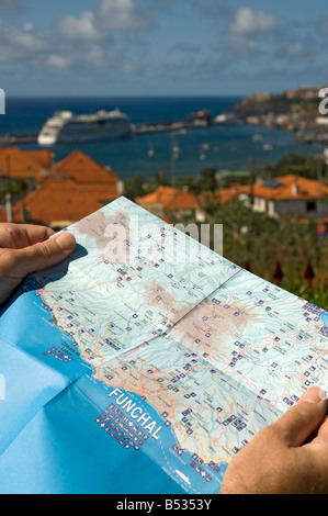 Gros plan de l'homme tenant une carte avec le port de Funchal en arrière-plan Madère Portugal Europe de l'UE Banque D'Images