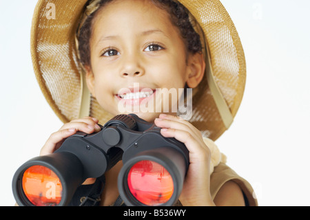 Mixed Race boy dans safari hat holding binoculars Banque D'Images