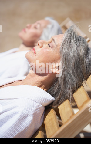 Les amis de dormir sur des chaises longues à resort Banque D'Images