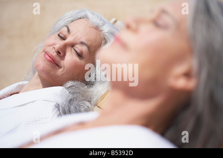 Les amis de dormir sur des chaises longues à resort Banque D'Images