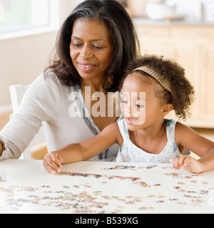 Grand-mère de l'Afrique aidant petite-fille mis ensemble un puzzle Banque D'Images