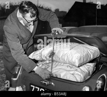 La pénurie de charbon a frappé de nombreux cet hiver, les entrepreneurs sont faibles si pas de stocks et ne sais pas quand le prochain arrivera de quota. Assistant-gérant James Maddox crams le coffre d'une voiture du client avec des sacs de Gloco. Janvier 1963 P017810 Banque D'Images