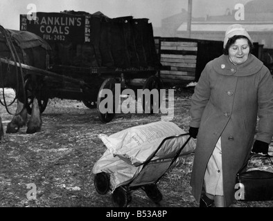 La pénurie de charbon a frappé de nombreux cet hiver, les entrepreneurs sont faibles si pas de stocks et ne sais pas quand le prochain arrivera de quota. Un client chanceux roues à l'opposé deux sacs de gloco à partir de la cour. Janvier 1963 P017812 Banque D'Images