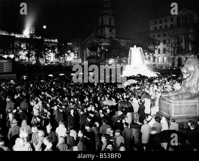 Cheers sous la pluie. Des milliers Trafalgar-square coincé comme la pluie coule sur la nuit dernière (jeudi 15-10-64) et, à la vue du Parlement, regardé les parties se battant pour le contrôle du pays. Ils ont applaudi, hués sang - et certains d'entre eux ont même sauté dans la fontaine les bassins dans leur excitation - comme les résultats des élections ont été flashés à la foule après quelques instants sur un grand écran de télévision. Octobre 1964 * P018731 Banque D'Images