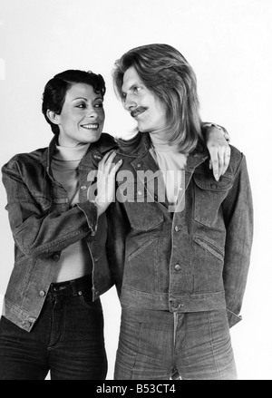 - La mode des années 70 : l'homme qu'elle. Elle est prise en charge de lui ? ;Couple wearing jeans et vestes en denim.;l'homme aux cheveux longs et moustache. Femme aux cheveux courts.;Mars 1976 P017328 Banque D'Images