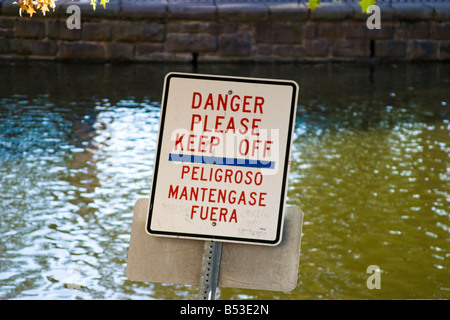 Inscrivez-vous dans un parc à côté de l'étang DANGER lecture VEUILLEZ GARDER OFF Banque D'Images