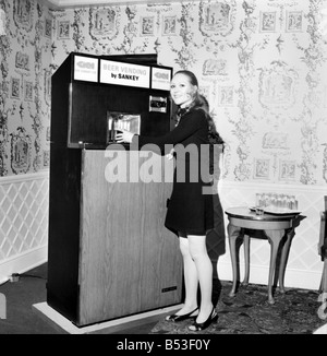 Inventions : la première bière réfrigérée automatique distributeur automatique a été démontré par la Division de la brasserie GKN Sankey Ltd., de personnel, à Bilston Quaglino's Bury Street, Londres. Femme avec l'avant de l'autobarmaid ouvrir montrant l'intérieur. Décembre 1969 Z11595 Banque D'Images