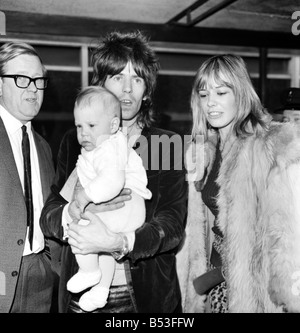 Rolling Stones, Charlie Watts et Keith Richard est arrivé aujourd'hui à l'aéroport de Heathrow à partir de Los Angeles. Ils ont été accueillis par Charlie Watts' femme et de sa fille, et la petite amie de Keith Richard, Anita Pallenberg avec leur bébé de 4 mois Marlon. Rolling Stone Keith Richard et Anita Pallenberg avec leur bébé Marlon à Heathrow aujourd'hui. Décembre 1969 Z11832 Banque D'Images