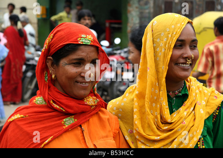 Deux femmes tribales dans des vêtements colorés et portant des foulards de tête à pied dans une rue à Bangalore, Inde. Banque D'Images