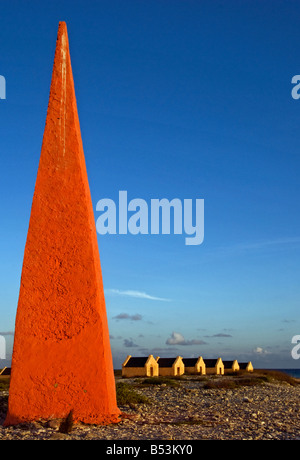 Obélisque rouge et cabanes d'esclaves dans la lumière du soir près de la salines solaires sur Bonaire, Antilles néerlandaises dans les Caraïbes Banque D'Images