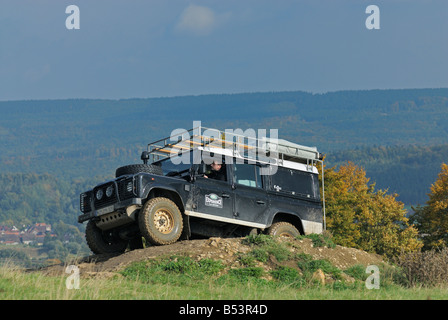 2000s noir Land Rover Defender 110 sur une piste forestière dans le Weserbergland. Banque D'Images