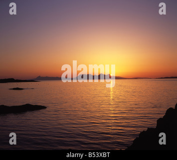 Vue sur l'île d'Eigg et l'île au coucher du soleil De Rum Silhouetting les Cullins de Rum Glenuig Moidart Western Highlands écossais Banque D'Images