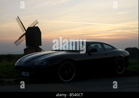 Voiture Jaguar moderne au coucher du soleil. Banque D'Images