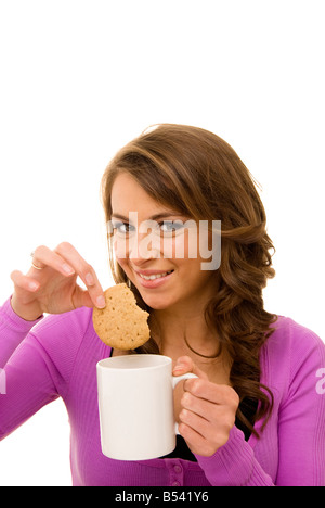Femme en biscuit tremper une tasse de thé Banque D'Images