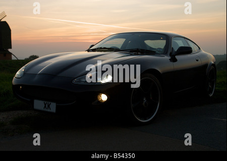 Voiture Jaguar moderne au coucher du soleil. Banque D'Images