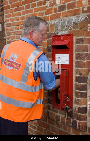 Postman travaillant pour la collecte de Royal Mail mail d'une boite aux lettres Banque D'Images