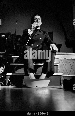 Artiste de cabaret et de chant au top coach Bob Anthony est d'effectuer un marathon non-stop dans le chant de l'aide de la charité. Après la formation pendant 10 ans, 18 heures par jour, Bob réalise son rêve et se montrer au monde son chant moderne et des techniques de respiration qui jusqu'à présent n'ont pas été pratiqué par tout chanteur.;avec plus de 15 heures sur son exploit. Bob Anthony se détend avec ses pieds dans un bol d'eau sur la scène du Lyceum - toujours le chant. ;Novembre 1969 ;Z10762-002 Banque D'Images