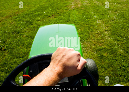 Première personne de tondre la pelouse sur une circonscription tondeuse John Deere. Banque D'Images