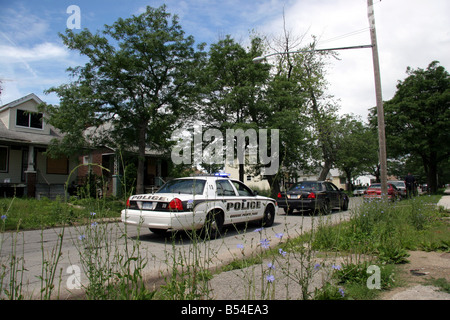 Grosse Pointe Park voiture de police effectuant un arrêt de la circulation dans un quartier pauvre de Detroit au Michigan Banque D'Images