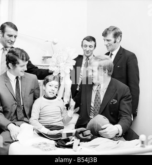 15 ans, Nigel Shadbolt de Chipping Campden. Gloucs, qui est à l'hôpital St. Mary, Paddington en attente d'une greffe de rein a été visité aujourd'hui par 6 de ses héros. Les membres de l'équipe de football Manchester City, qui avant de jouer et de battre West Ham à Upton Park est arrivée à l'hôpital avec kit de jeu et images de Nigel. Nigel avec son héros - Francis Lee tirer un visage pour montrer ce qu'il pense de West Ham. Nigel est titulaire d'une rosette fait maison qu'il a donné à Tony livre avec L-R : Coach Maclom Allison, Doyle, Micke Summerbee, Tony Book et Francis Lee. Décembre 1969 Z11713 Banque D'Images