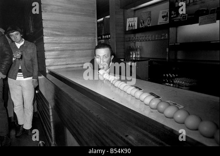 Travailler sur un oeuf est la sous-évaluation de la journée à 46 ans Taffy Gordon de Middleton, Lancashire. Parce que Taffy regulalrly downs 24, et hier, dans une tentative pour battre le record pour le Guiness Book des records il avala 48 en l'espace de 47 secondes. Sa tentative de tire d'enregistrement de quatre verres de bière contenant chacune douze oeufs cassés. ;Novembre 1969 ;Z10899-005 Banque D'Images