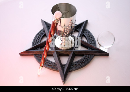 Un autel rituel mis en place sur un fond blanc, à l'aide d'un Quartz Gemstone Pentacle, Calice, baguette et boule de cristal. Banque D'Images