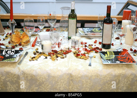 Table de Noël décorée avec des bougies de vin fleurs pétales Banque D'Images