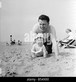 Neuf mois Paul Kemshell de ramper sur le sable à Rhyl avec son papa Monsieur Brian Kemshell de Muro. Juin 1960 M4315-014 Banque D'Images