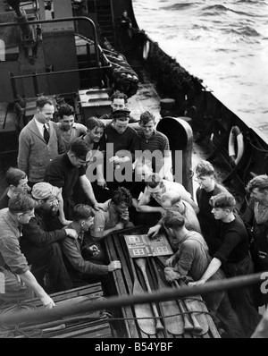 Photo prise à bord d'un des navires d'Escorte HMS lors d'un convoi de la côte ouest de l'Angleterre. Certains membres d'équipage sont regarder un jeu passionnant de Ludo sur le pont inférieur pendant une courte période de repos. ;Octobre 1942 ;P012182 Banque D'Images