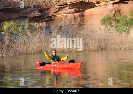 Un homme poissons voler à partir de son kayak au lac Powell, Utah Banque D'Images