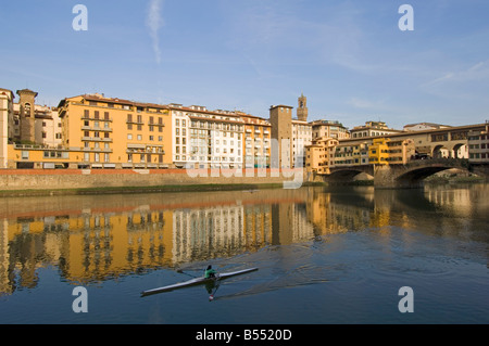 Un côté ouest vue sur le Ponte Vecchio et des bâtiments traditionnels reflètent dans l'Arno avec un seul rameur. Banque D'Images