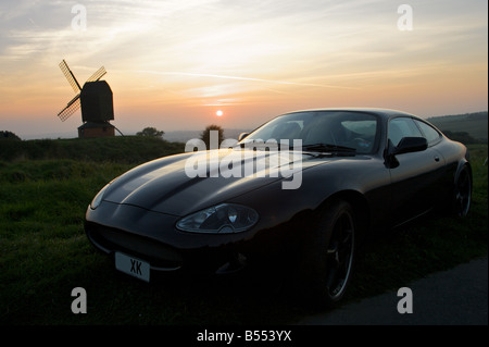 Voiture Jaguar moderne au coucher du soleil. Banque D'Images