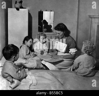 Matrone Doris Naughten lit des contes de fées à (de gauche à droite) Nigel Paneth, Susan Conen, un enfant américain, Christopher Buckmaster et Paul Ganjou, avant d'aller au lit. Octobre 1949 P012144 Banque D'Images