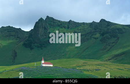 Église entourée de falaises vert, Vik, Islande Banque D'Images