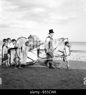 Divertissement : Punch and Judy Show. Après avoir mis leurs sous dans son vieux chapeau haut de la roue à l'aide public au fil du spectacle les sables avant la marée rattrape le professeur John Stafford et son Punch et Judy Show à Torbay, dans le Devon. Septembre 1953 D5619-001 Banque D'Images