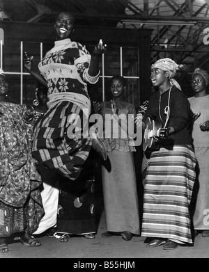 Magie africaine : en arrivant à Londres aujourd'hui pour une visite de retour étaient la Compagnie de Danse nationale du Sénégal. Ils sont ici pour une saison à la semaine 3 Saville theatre. Leur spectacle est intitulé 'African Magic'. Mlle Fatou Diame l'un des principaux danseurs de la compagnie ici effectue un saut sur la plate-forme de Victoria Stn. arrière-plan tandis que d'autres membres de la société de faire avec la musique. Avril 1965 P012729 Banque D'Images