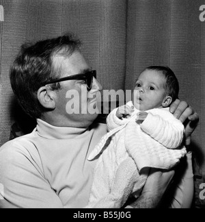 Famille : père tenant son enfant nouveau-né à leur maison. Décembre 1969 Z12116 Banque D'Images