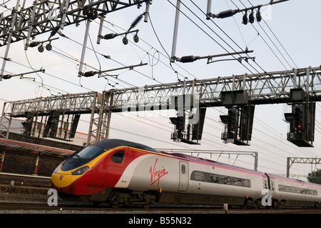 Un pendolino Virgin Trains inter-villes train arrivant en cours d'exécution sur la West Coast Main Line arrivant à la gare de Crewe UK Banque D'Images