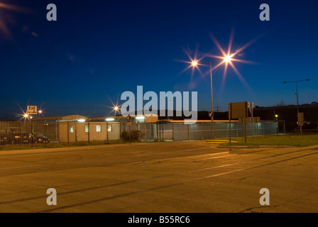 Une vue à travers un dock yard à Southampton au lever du soleil avec l'éclairage des feux de la rue du Parvis Banque D'Images