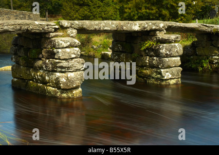 La rivière Dart coule sous un pont en pierre clapper sur Devon Dartmoor UK Banque D'Images