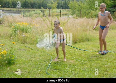 Deux garçons jouer sur l'herbe près de house Banque D'Images