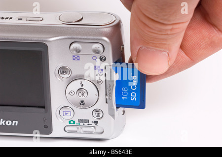 (Carte mémoire secure digital) (SD) carte d'appareil photo numérique compact pour appareil photo sur fond blanc d'être introduit dans l'appareil photo Banque D'Images