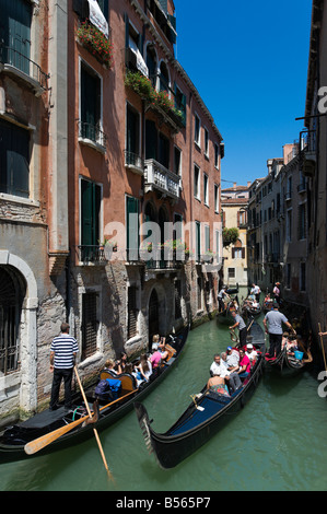 Les touristes en gondoles sur un canal étroit dans le quartier de San Marco, Venice, Veneto, Italie Banque D'Images