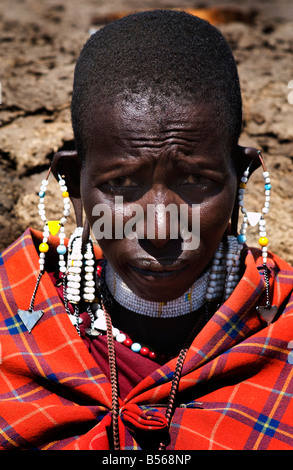 Portrait d'une jeune femme adulte masaii parée de ses bijoux et couverture rouge traditionnelle avec bandes Amyn Nasser amynnasser [r Banque D'Images