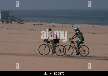 Deux femmes cyclistes sur leur matin balade le long de la plage Banque D'Images