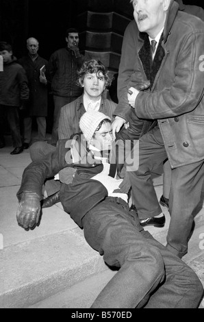 Les deux grévistes de la faim qui ont été le jeûne sur le trottoir à l'angle de Whitehall et Downing Street depuis la veille de Noël, veillée de leur aujourd'hui qu'ils l'a remis une pétition à n° 10. Les hommes s'est effondrée et a dû être effectué à la porte de n° 10 et après avoir remis la pétition ont reçu le traitement à l'arrivée des transports de les éloigner. Les deux hommes ont été pour protester contre la loi sur les pouvoirs spéciaux de l'Irlande du Nord. Christopher Maloney est réconforté par ses amis après s'effondrer à l'extérieur no 10. Décembre 1969 Z12438-001 Banque D'Images