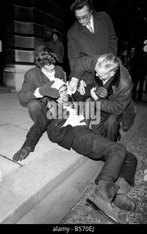 Les deux grévistes de la faim qui ont été le jeûne sur le trottoir à l'angle de Whitehall et Downing Street depuis la veille de Noël, veillée de leur aujourd'hui qu'ils l'a remis une pétition à n° 10. Les hommes s'est effondrée et a dû être effectué à la porte de n° 10 et après avoir remis la pétition ont reçu le traitement à l'arrivée des transports de les éloigner. Les deux hommes ont été pour protester contre la loi sur les pouvoirs spéciaux de l'Irlande du Nord. Christopher Maloney est réconforté par ses amis après s'effondrer à l'extérieur no 10. Décembre 1969 Z12438-002 Banque D'Images