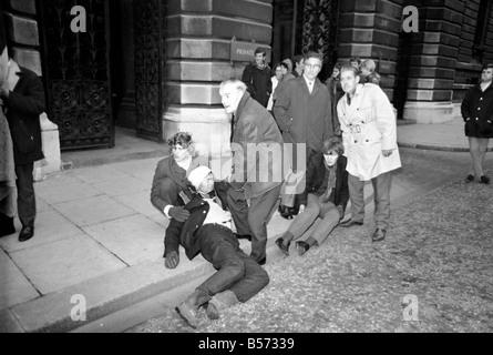 Les deux grévistes de la faim qui ont été le jeûne sur le trottoir à l'angle de Whitehall et Downing Street depuis la veille de Noël, veillée de leur aujourd'hui qu'ils l'a remis une pétition à n° 10. Les hommes s'est effondrée et a dû être effectué à la porte de n° 10 et après avoir remis la pétition ont reçu le traitement à l'arrivée des transports de les éloigner. Les deux hommes ont été pour protester contre la loi sur les pouvoirs spéciaux de l'Irlande du Nord. Allongé sur le trottoir à l'extérieur no 10, Christopher Maloney qui s'est effondré après avoir remis une pétition. Décembre 1969 Z12438-005 Banque D'Images