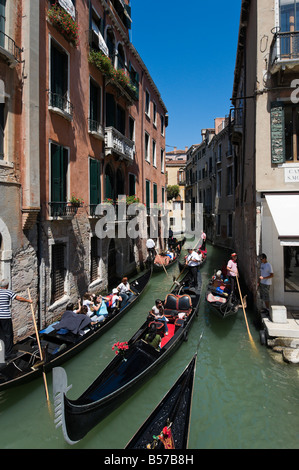 Les touristes en gondoles sur un canal étroit dans le quartier de San Marco, Venice, Veneto, Italie Banque D'Images