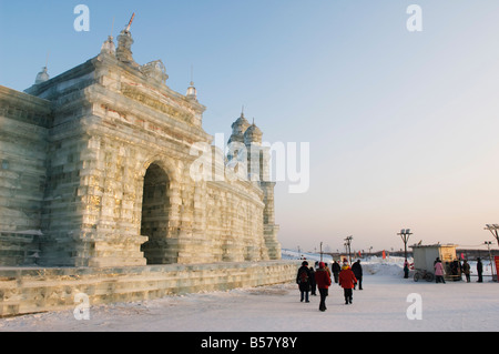 Les touristes en passant devant les sculptures de neige et de glace au festival de lanternes de glace, Harbin, province de Heilongjiang, Chine Banque D'Images